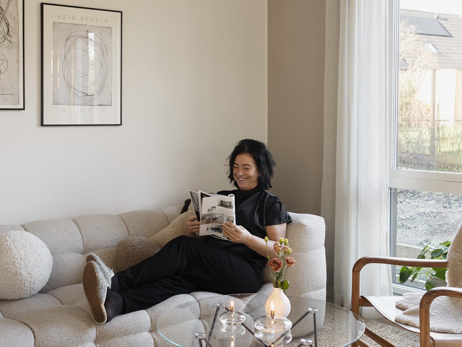 Kvinna läser en tidning i soffan.
